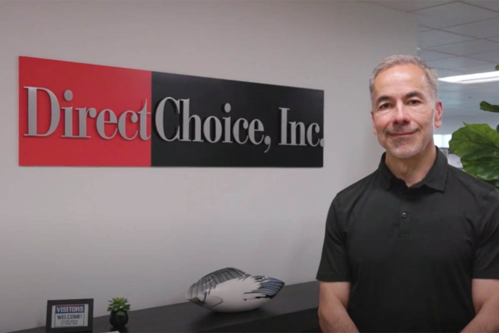 Nick Lanzi, standing alongside the sign for his business, Direct Choice, Inc.