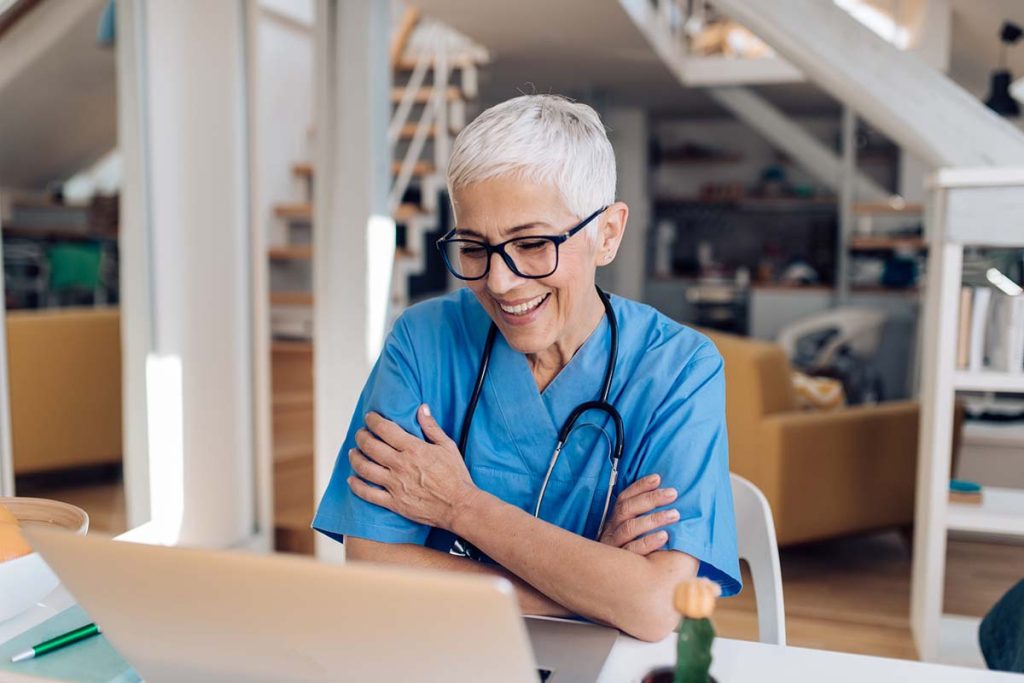 Mature female doctor working online with her patients.
